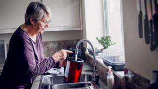 woman fills kettle