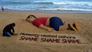 Indian artist Sudarsan Pattnaik works on a sand sculpture depicting drowned Syrian boy Alan Kurdi at Puri beach, some 65 km away from Bhubaneswar, on September 4, 2015.