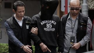 Hong Kong attack; One of the two assailants helps police inspect the scene of crime
