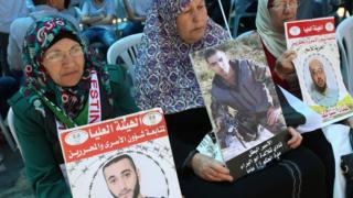 Palestinians in the West Bank city of Ramallah hold pictures of relatives being detained in Israeli jails during a rally calling for the release of Palestinian prisoners in Israel, 18 April 2017.