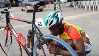 Un cycliste Béninois réparant son vélo lors du tour international cycliste de la Cedeao à Lagos en 2013 (illustration)
