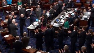 US Senator John McCain (R-AZ), who had been recuperating in Arizona after being diagnosed with brain cancer, acknowledging applause as he arrives on the floor of the U.S. Senate after returning to Washington for a vote on healthcare reform in Washington, US 25 July 2017