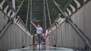 Turista sobre plataforma suspendida sobre un acantilado