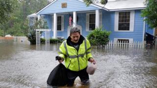 Flood victim carries food salvaged from his home - 29 August