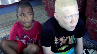 Esala Seru, right, watching television with his brother