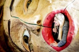 An employee looks out an artwork as it is put on display during preparations for the fair.