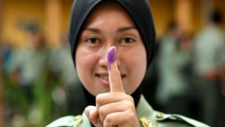 A Malaysian Army forces shows her inked finger after casting her vote during an early vote for the 14th general election in Kuala Lumpur on May 5, 2018