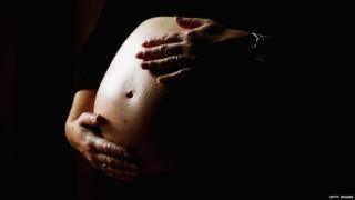 File photo: A pregnant woman holds her stomach