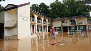 A man stands in ankle-deep water in South Murwillumbah.