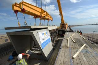 The roof of the new tunnel entrance structure being lowered into place