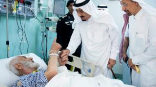 Saudi King Salman holds the hand of an injured pilgrim at a hospital in Saudi Arabia's holy Muslim city of Mecca - 12 September 2015