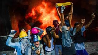 A masked group of youths take part in an attack on the administration headquarters of the Supreme Court of Justice as part of protests against President Nicolas Maduro in Caracas, on June 12, 2017.