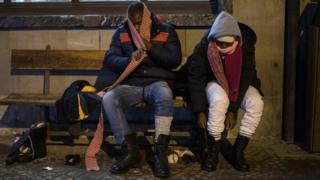 Migrants from Guinea don winter shoes and apparel donated by a charity organisation in Bardonecchia, Italy, 13 January 2018