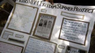 A poster held outside of 2005 trial shows the original missing poster for the men and dedications and quotes for them