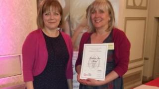 Stephanie Fricker seen on the right with a representative from the Queen's Nursing Institute