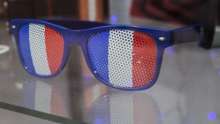 A pair of sunglasses in the colours of the French flag