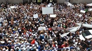 Hundreds of demonstrators of the Berber community stage a protest in front of a walled area where Algier"s newspapers are headquartered in support of Berbers in the southern Ghardaia region where at least 22 people have died in ethnic unrest, in Algiers, Algeria, Wednesday, July 8, 2015.