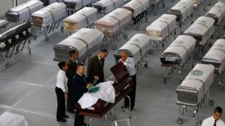 Petugas pemakaman menutup peti mati yang dihias dengan logo Chapecoense, berisi jasad anggota tim di rumah pemakaman San Vicente di Medellin, Kolombia, Jumat, 2 Desember 2016.