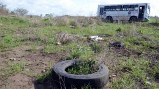 A general view shows a bus (back) at a field as members of the General Prosecutor's Office of the State of Veracruz (unseen) prevented access to the Colinas de Santa Fe in Veracruz, Mexico, 14 March 2017