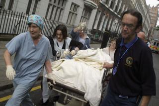 Emergency workers take a body on a stretcher from Russell Square tube station