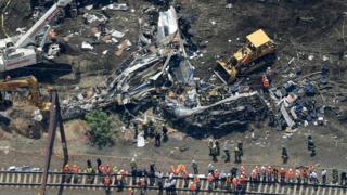 Investigators and first responders work near the wreckage of Amtrak Northeast Regional Train 188, from Washington to New York, that derailed yesterday May 13, 2015 in north Philadelphia