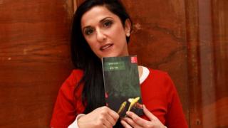 A file picture taken on December 31, 2015, shows Israeli author Dorit Rabinyan posing with her Hebrew-language novel titled "Gader Haya"