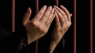 Hands behind bars