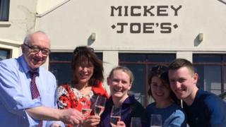 Michael Gallagher, left, celebrates with colleagues after the winning ticket was sold in his shop, Mickey Joe's Country Store in Carrigart