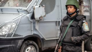 Policeman stands guard as they patrol a street on the anniversary of the 2011 uprising