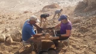 Ziad Abu Ganem and student filter material from cave