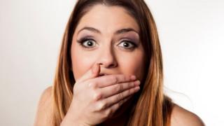 Una mujer con cara de asombro, tapándose la boca
