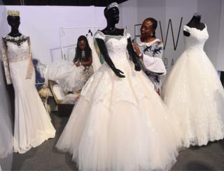 Employess of La Viva Bridal Concepts present wedding dresses during the Lagos Bridal Fashion Week in Lagos on May 4, 2018.