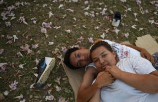 Central American migrants - taking part in a caravan called "Migrant Viacrucis"- rest at a sports centre field.
