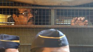 Mustafa Dossa sits inside a police van as he leaves from Arthur Road Jail for a special court in Mumbai (16 June 2017)