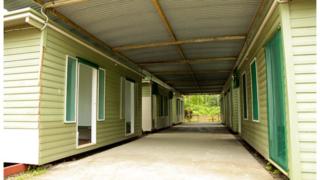 Handout photo showing six wooden huts on Manus in October 2012