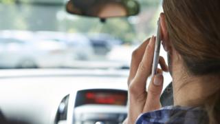 Woman on mobile phone in her car
