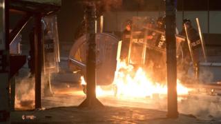 Petrol bomb is thrown at police officers in Kosovo capital Pristina as clashes broke out after the arrest of a prominent opposition politician Albin Kurti on Monday, Oct. 12, 2015.