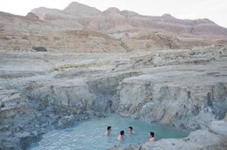 Israelis bathe in a hot water spring on the shore of the Dead Sea near the Israeli Kibbutz of Ein Gedi