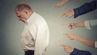 man looks sad as lots of fingers are pointed at him