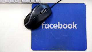 A computer mouse on a Facebook mousemat