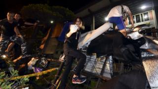 Protesters climb over a barricade to enter the Ministry of Education in Taipei, Taiwan, 31 July 2015