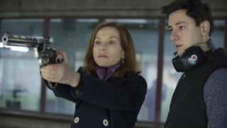 Escena de la película en que la actriz empuña un arma al lado de un instructor.