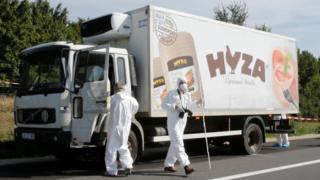 Forensic police officers inspect a parked truck in which migrants were found dead, on a motorway near Parndorf, Austria August 27, 2015