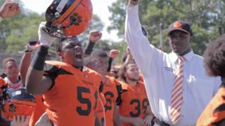 preston Brown and players on the team raise their fists