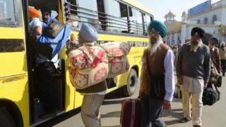 Indian Sikh pilgrims prepare to board a bus at the railway station in Amritsar (25 November 2012)