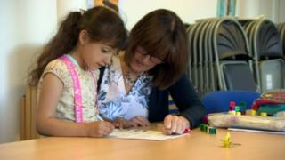 Child with teacher in classroom