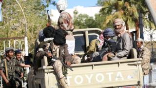 Fighters loyal to Yemen's government ride on the back of a truck