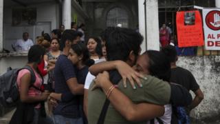 Residents embrace to celebrate that Rev. Jose Luis Sanchez Ruiz has been found alive, at a his church in Catemaco, Veracruz state, Mexico, Sunday, Nov. 13, 2016