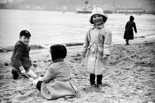 Three kids build a sandcastle in Rothesay in 1955.