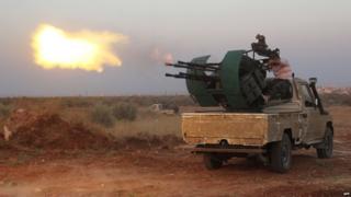 Rebel fighters fire a heavy machine gun during clashes with Syrian pro-government forces on the frontline facing Deir al-Zoghb, a government-held area in the north-western Idlib province, on August 31, 2015.